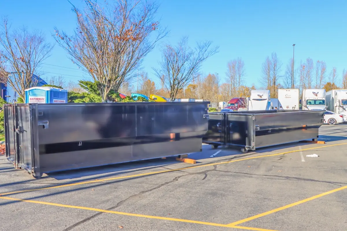 Professional dumpster rental service with roll-off container on residential driveway in Beeville